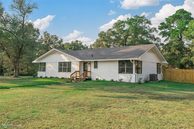 ranch-style house featuring a front yard and central AC unit