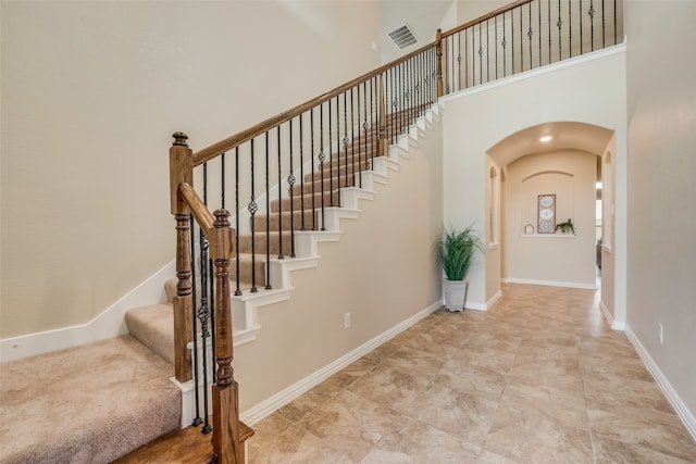 stairs featuring a high ceiling