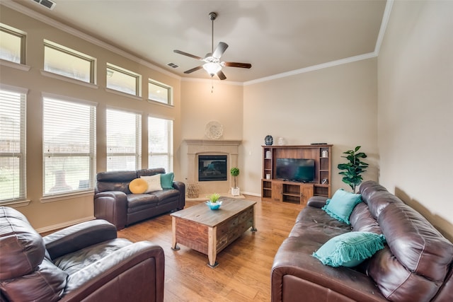 living room featuring light wood-type flooring, ornamental molding, and ceiling fan