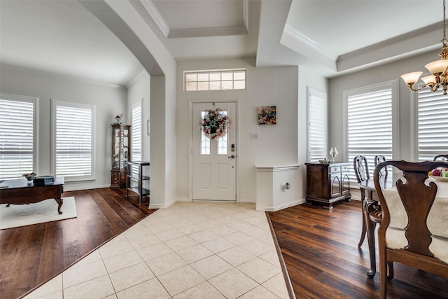 foyer entrance featuring hardwood / wood-style floors, ornamental molding, and a healthy amount of sunlight