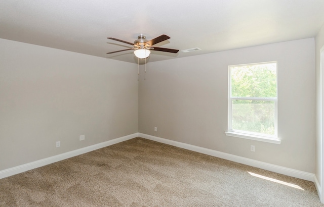 carpeted spare room with a wealth of natural light and ceiling fan