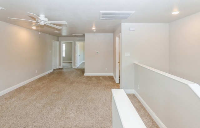 unfurnished room featuring light carpet and ceiling fan