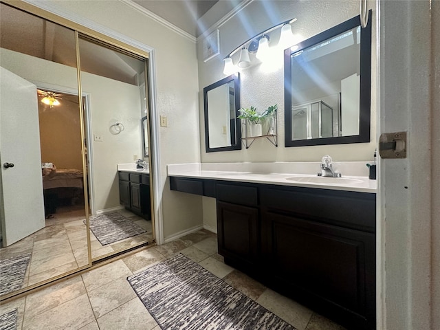 bathroom featuring walk in shower, crown molding, vanity, and ceiling fan