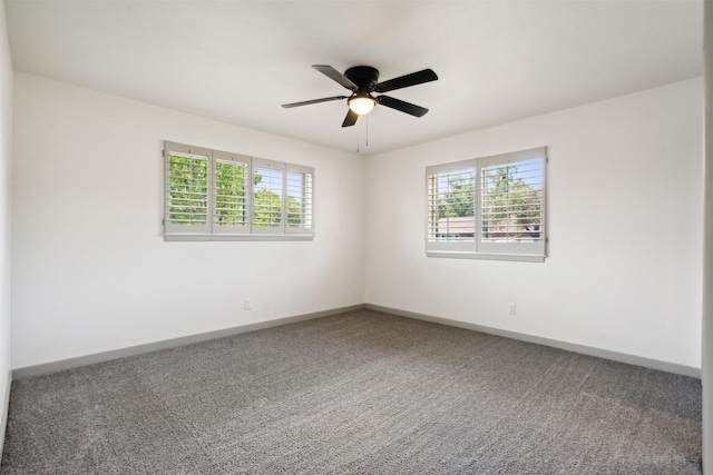 carpeted spare room featuring plenty of natural light and ceiling fan