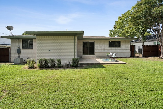 rear view of house featuring central air condition unit, a patio area, and a yard