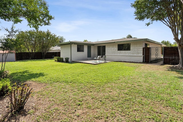 rear view of property with a yard and a patio