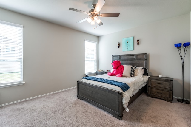 carpeted bedroom with multiple windows and ceiling fan