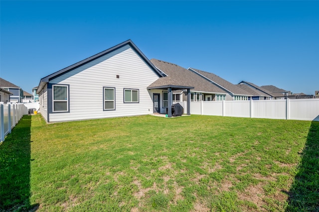 rear view of house featuring a yard