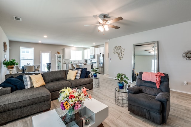 living room with light hardwood / wood-style floors and ceiling fan