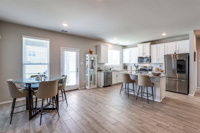 kitchen with white cabinetry, stainless steel appliances, and a wealth of natural light