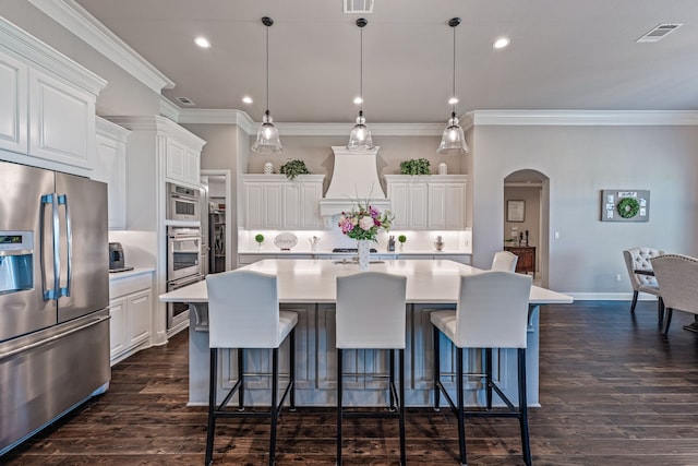kitchen with a kitchen bar, arched walkways, visible vents, appliances with stainless steel finishes, and light countertops
