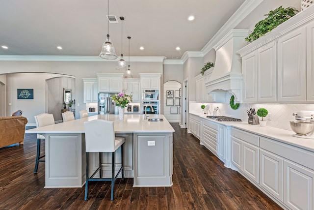 kitchen featuring a kitchen breakfast bar, dark wood-type flooring, decorative light fixtures, and a spacious island