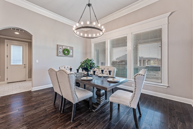 dining area featuring baseboards, arched walkways, ornamental molding, a chandelier, and wood finished floors