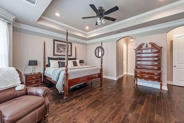 bedroom with ornamental molding, a tray ceiling, ceiling fan, and dark hardwood / wood-style flooring