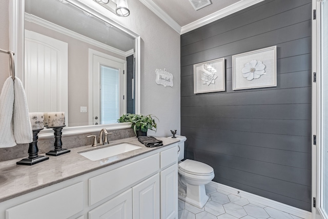 bathroom featuring vanity, crown molding, wooden walls, toilet, and tile patterned floors