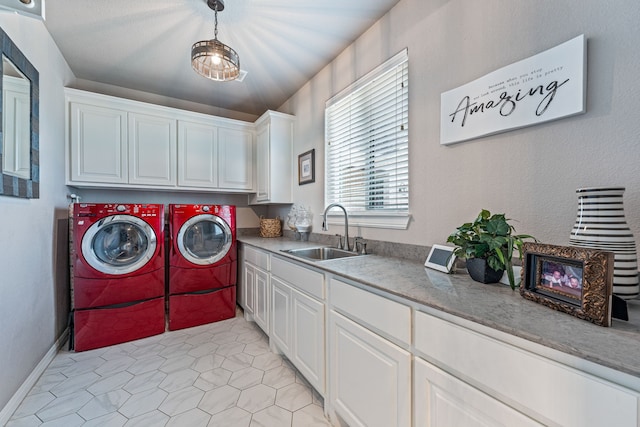 washroom featuring light tile patterned floors, sink, washing machine and clothes dryer, and cabinets