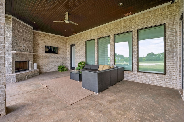 view of patio / terrace with ceiling fan and an outdoor living space with a fireplace
