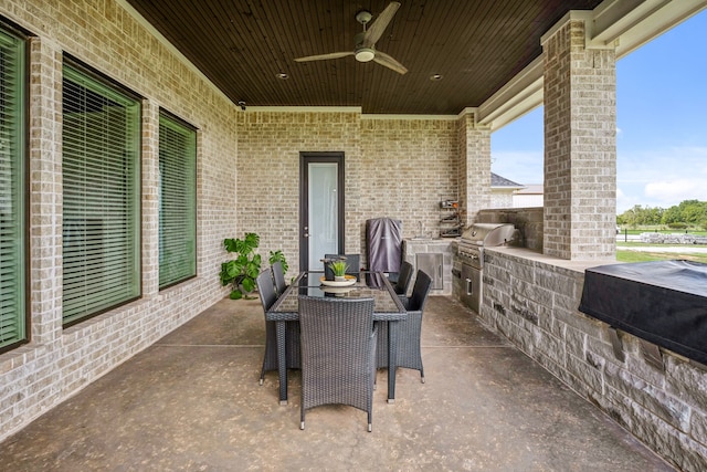 view of patio featuring exterior kitchen, area for grilling, and ceiling fan