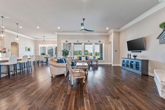 living area featuring a healthy amount of sunlight, arched walkways, and dark wood-style floors