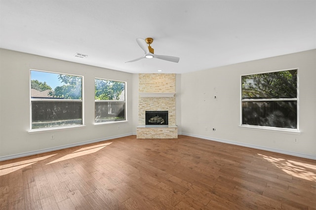 unfurnished living room featuring wood-type flooring, a fireplace, and ceiling fan