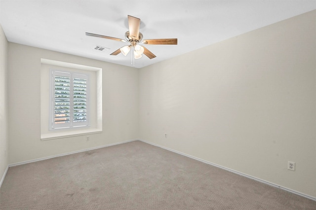 carpeted spare room featuring ceiling fan