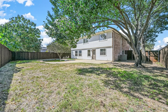 back of property with a patio, a yard, and central air condition unit