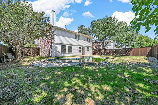 rear view of property featuring a yard