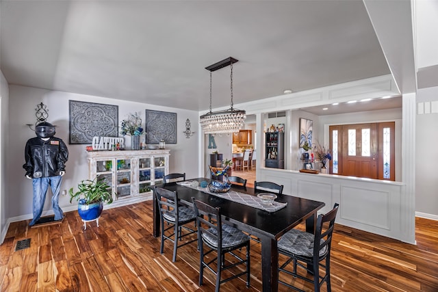 dining area featuring a notable chandelier and dark hardwood / wood-style floors