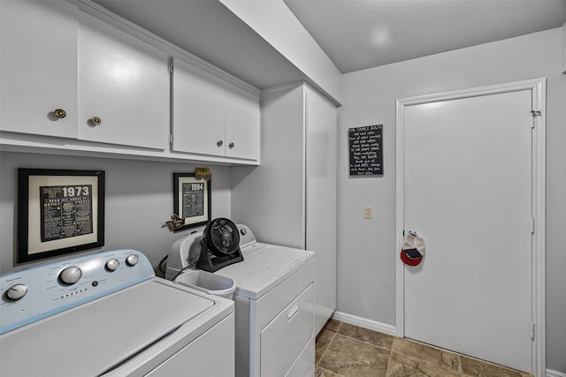 clothes washing area featuring cabinets and washing machine and dryer