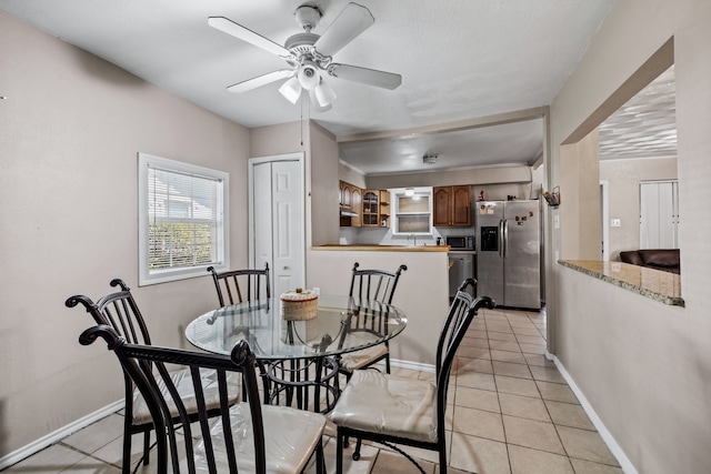 dining room with ceiling fan and light tile patterned flooring