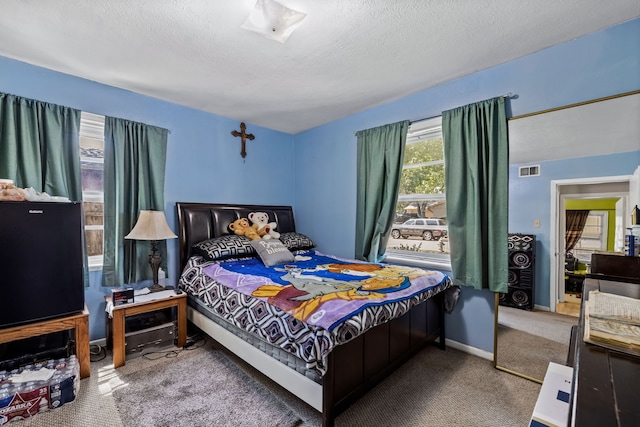 bedroom with carpet and a textured ceiling