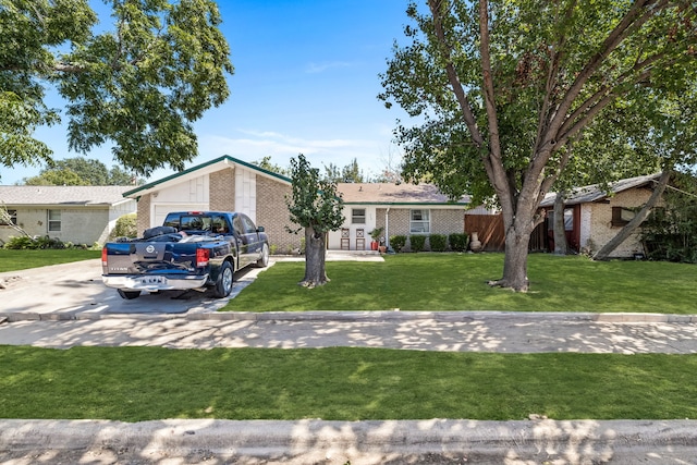 ranch-style home featuring a garage and a front lawn