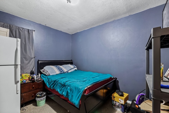 carpeted bedroom featuring white refrigerator and a textured ceiling