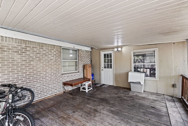 miscellaneous room featuring brick wall and dark hardwood / wood-style flooring