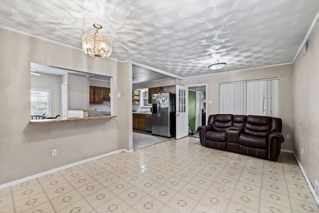 living room with a textured ceiling, ornamental molding, and an inviting chandelier