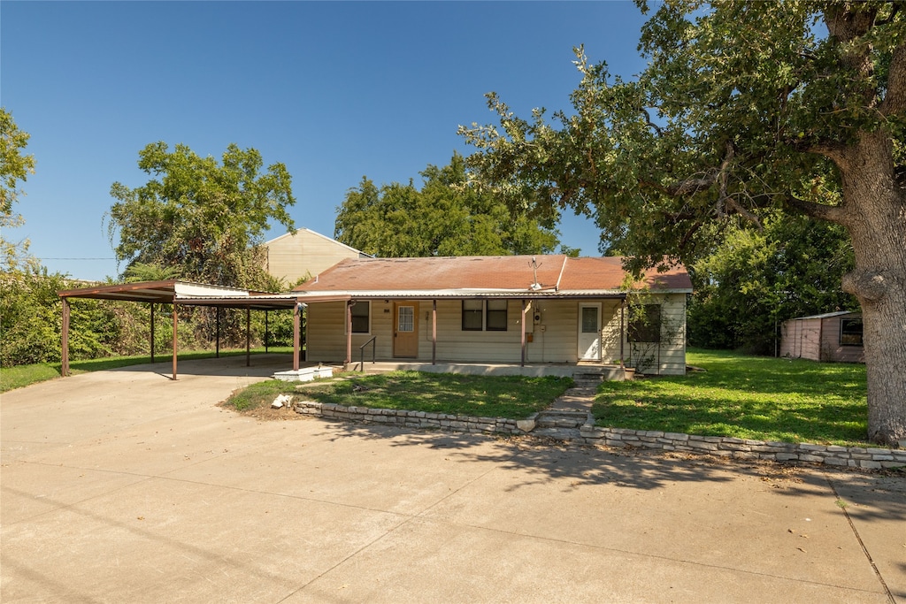 view of front facade featuring a carport, a porch, and a front lawn