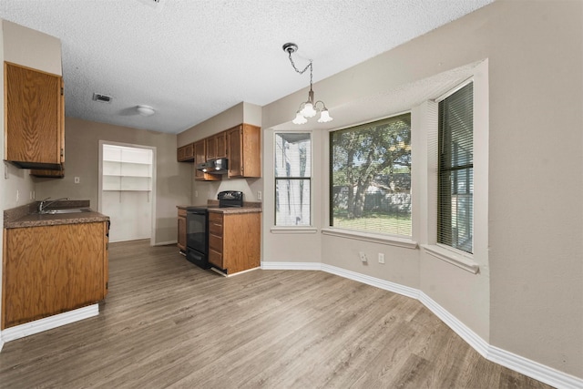 kitchen with pendant lighting, a textured ceiling, black electric range, dark hardwood / wood-style floors, and a notable chandelier