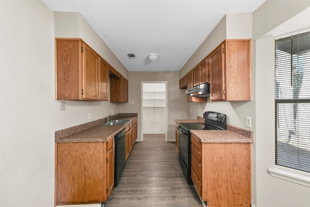 kitchen featuring black appliances, a textured ceiling, hardwood / wood-style floors, and sink