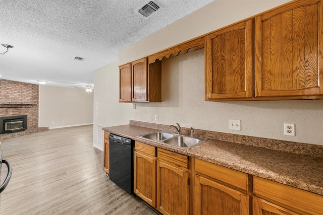 kitchen with light hardwood / wood-style flooring, dishwasher, a textured ceiling, and sink