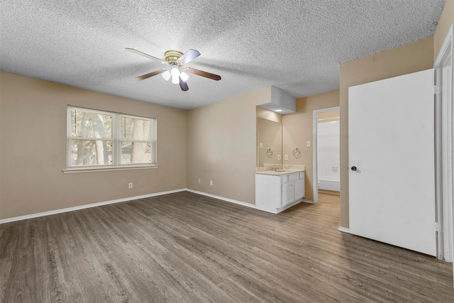 unfurnished living room with a textured ceiling, hardwood / wood-style floors, and ceiling fan