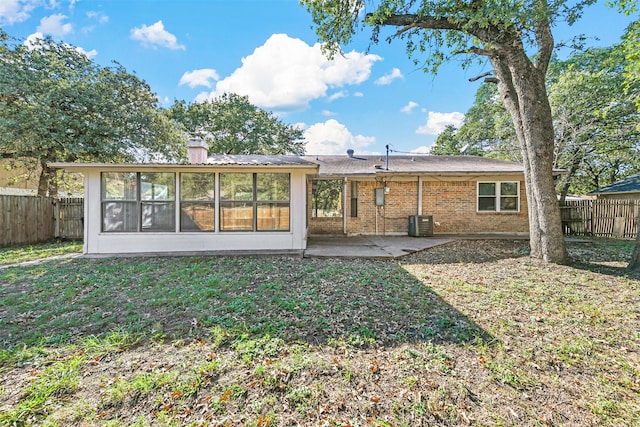 rear view of property featuring a sunroom, a yard, and a patio