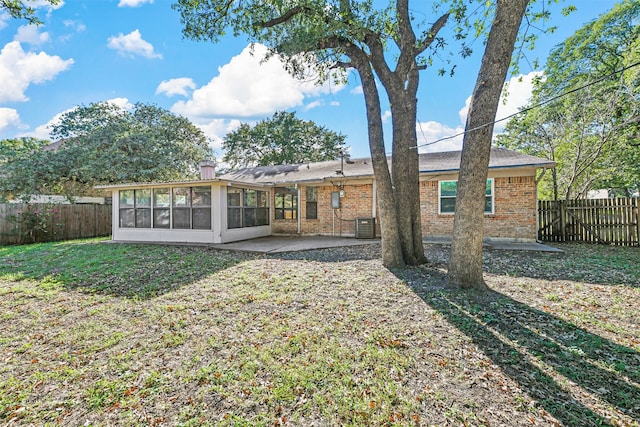 back of house featuring a sunroom, a lawn, a patio area, and central air condition unit