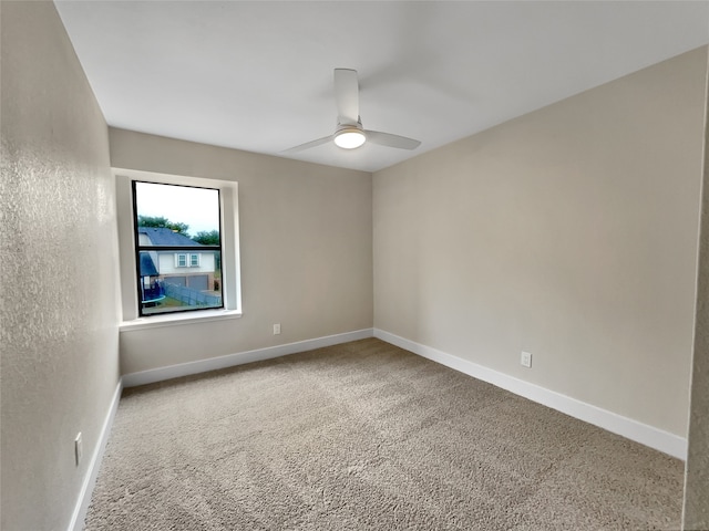 carpeted spare room featuring ceiling fan