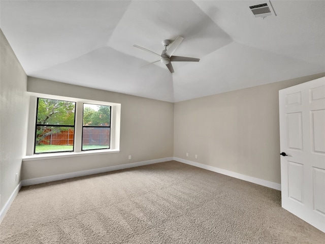 spare room with carpet flooring, vaulted ceiling, and ceiling fan