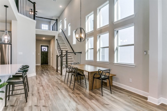 dining space featuring stairs, light wood-style flooring, and baseboards