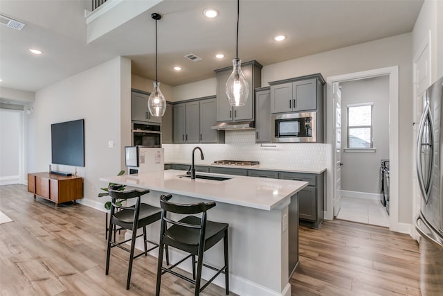 kitchen with gray cabinetry, visible vents, appliances with stainless steel finishes, and a sink