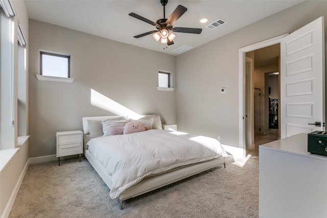 carpeted bedroom with visible vents, multiple windows, and baseboards