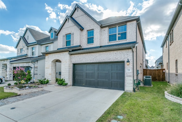 view of front of property with a garage, central air condition unit, and a front lawn