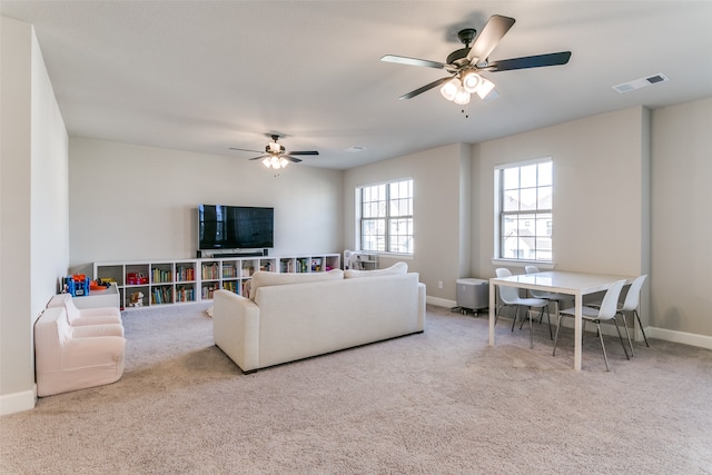 carpeted living room featuring baseboards, visible vents, and ceiling fan