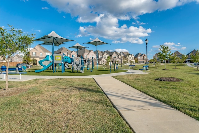 community playground featuring a lawn and a residential view